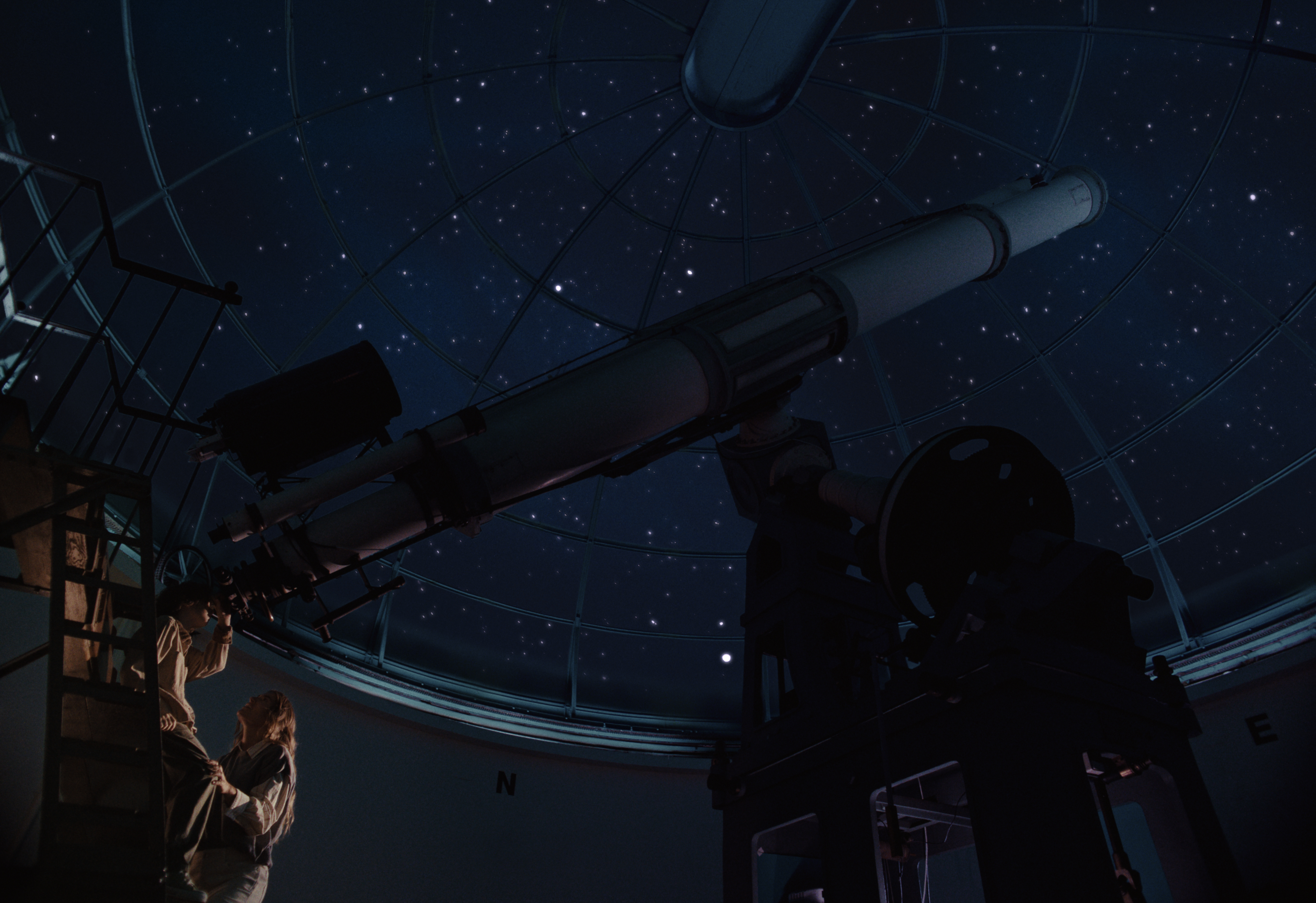 Observatory and telescope under a night sky.